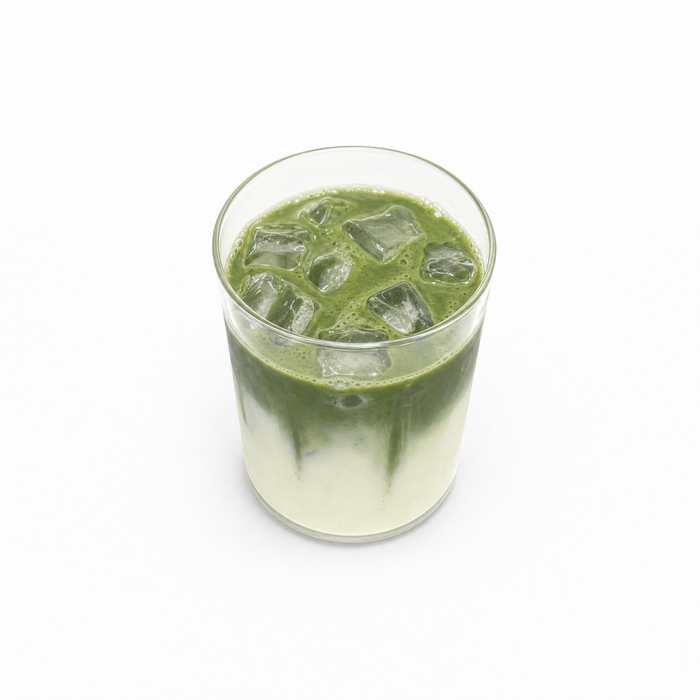 Iced matcha in tall glass, condensation, hand with gold ring, summer light